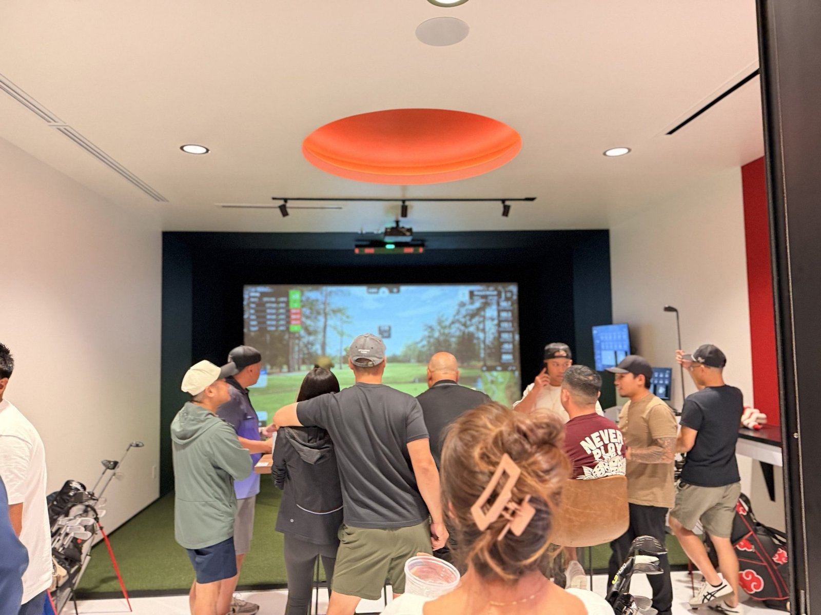 A group celebrating together in a Birdie Central simulator bay